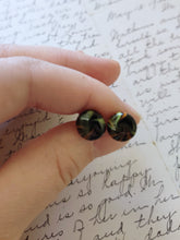 Load image into Gallery viewer, Yellow, black, and orange swirl earrings held between finger and thumb