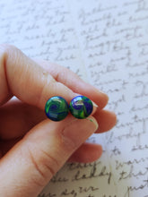 Load image into Gallery viewer, Yellow, blue, and purple swirl earrings held between finger and thumb