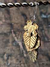 Load image into Gallery viewer, One dangle earring with fall leaves cascading down as if stacked on top of each other. A maple leaf is on top, followed by a beech, an aspen, and a oak.