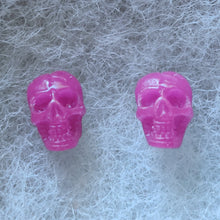 Load image into Gallery viewer, Pink skull shaped stud earrings that shimmer purple in the light. 
